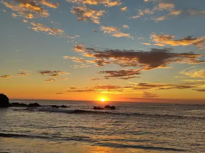 a sunset on the beach with the sun setting at Hakuna in San Juanillo