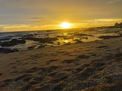 a sunset on a beach with the ocean at Hakuna in San Juanillo