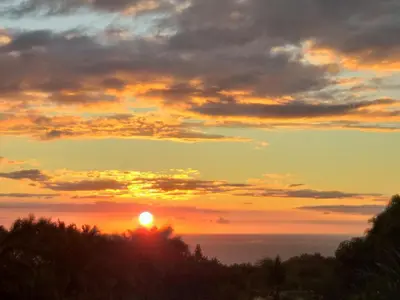 a sunset with the sun setting over the ocean at Hakuna in San Juanillo