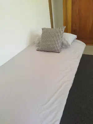 a white bed with two pillows on top of it at Hakuna in San Juanillo
