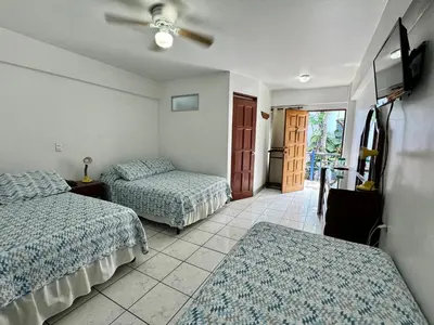 a hotel room with two beds and a tv at Hotel Cacts in San José