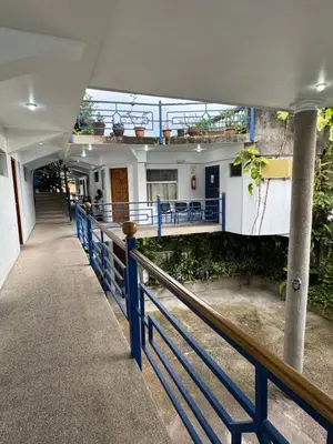 a hallway of a building with a blue railing at Hotel Cacts in San José