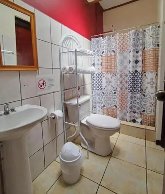 a bathroom with a toilet and a sink and a shower at Casa Cafetal Aeropuerto in Alajuela City