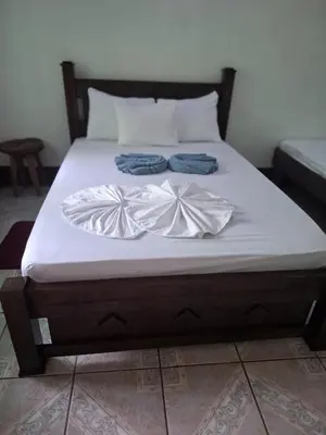 a bed with two towels on top of it at Cabinas Tortuguero Natural in Tortuguero