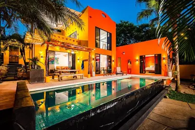 a house with a swimming pool in front of a house at A Tamarindo Sunset in Tamarindo