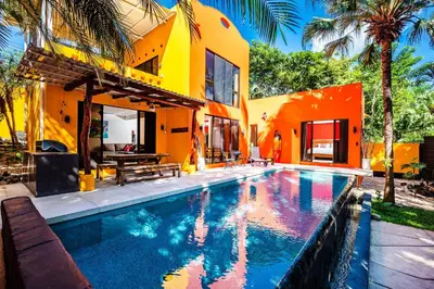 a house with a swimming pool in front of a house at A Tamarindo Sunset in Tamarindo