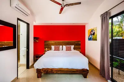 a bedroom with a bed with a red wall at A Tamarindo Sunset in Tamarindo