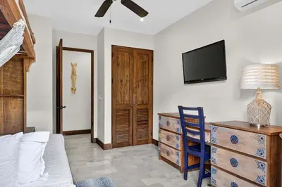 a living room with a tv on the wall and a dresser at Plaza Carlota 22 At Las Catalinas in Playa Danta