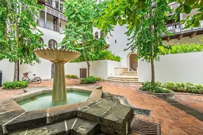 a fountain in the middle of a courtyard with trees at Plaza Carlota 22 At Las Catalinas in Playa Danta