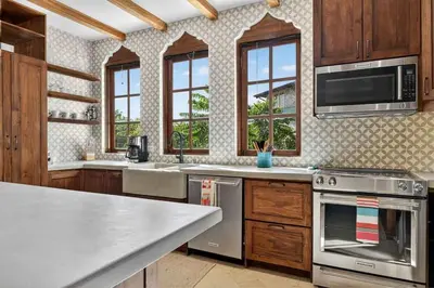 a kitchen with stainless steel appliances and wooden cabinets at Plaza Carlota 22 At Las Catalinas in Playa Danta