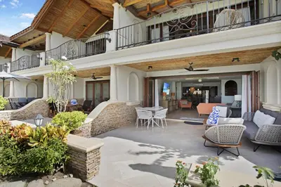 a patio with chairs and tables on a house at Palms 26 Sueños Del Sol in Playa Flamingo
