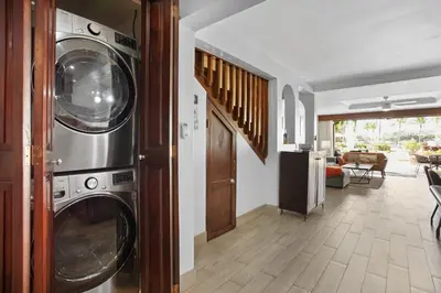 a living room with a washer and dryer in a house at Palms 26 Sueños Del Sol in Playa Flamingo