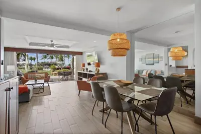 a dining room and living room with a table and chairs at Palms 26 Sueños Del Sol in Playa Flamingo