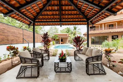 an outdoor patio with chairs and a table at Flamingo Estates 18- 4 Br House With Pool in Brasilito