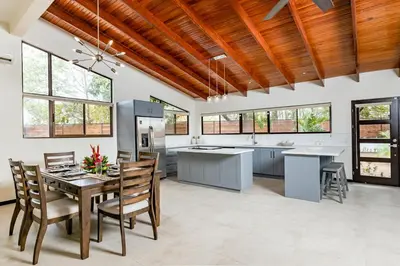 an open kitchen with a table and chairs and windows at Flamingo Estates 18- 4 Br House With Pool in Brasilito
