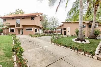 a house with palm trees in front of a driveway at Flamingo Estates 18- 4 Br House With Pool in Brasilito