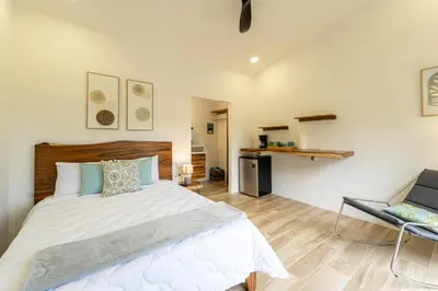 a bedroom with a large white bed and a chair at The Haven-Mar Vista 2 Br House With Pool And 1 Br Casita in Brasilito