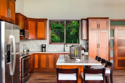 a kitchen with wooden cabinets and a table with chairs at Casa Vistas At Mar Vista in Brasilito