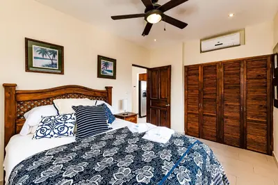 a bedroom with a bed and a ceiling fan at Punta Plata 523- Ocean View Condo in Playa Flamingo
