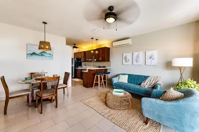 a living room with a blue couch and a table at Punta Plata 523- Ocean View Condo in Playa Flamingo