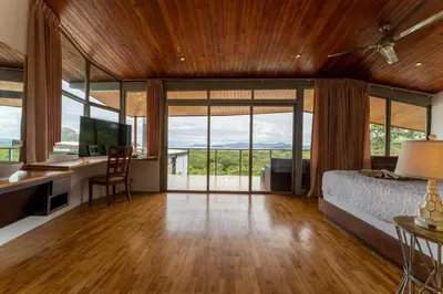 a bedroom with a bed and a desk with a computer at Casa Brisas Del Mar- Luxury 6 Bedroom Ocean View Home in Puerto Viejo