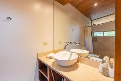 a bathroom with a sink and a large mirror at Casa Brisas Del Mar- Luxury 6 Bedroom Ocean View Home in Puerto Viejo