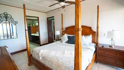 a bedroom with a four poster bed and a mirror at Presidential Suites 15-Oceanview Condo in Playa Flamingo