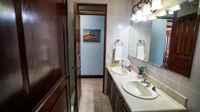 a bathroom with two sinks and a mirror at Presidential Suites 15-Oceanview Condo in Playa Flamingo
