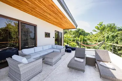 a patio with a couch and chairs and a table at Casa Sunset At Mar Vista in Playa Flamingo