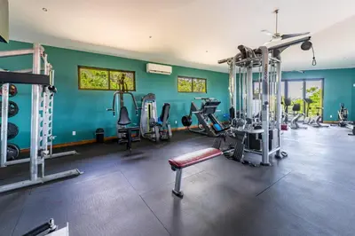 a gym with several tread machines in a room at Casa Sunset At Mar Vista in Playa Flamingo