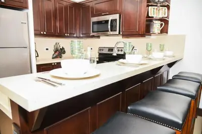 a kitchen with wooden cabinets and a white counter top at 360 Splendor 308F-Ocean View Residence-Breakfast in Playa Flamingo