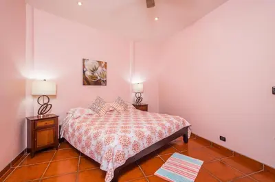 a bedroom with a bed and two night stands at Casa Suenos-Beautiful Beachfront House in Tempate
