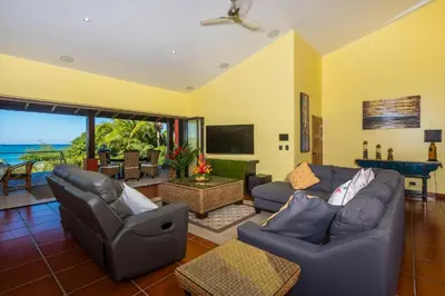 a living room with two couches and a television at Casa Suenos-Beautiful Beachfront House in Tempate