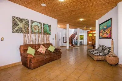 a living room with a couch and a guitar at Casa Suenos-Beautiful Beachfront House in Tempate
