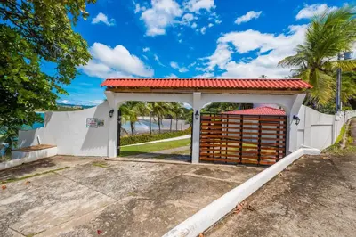 a white garage with a gate and a red roof at Casa De La Playa- Beachfront Home At Flamingo in Playa Flamingo