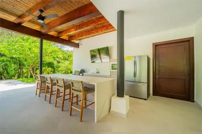 a kitchen with a table and chairs and a refrigerator at Villa Carao #3 - A Private 4 Bedroom Resort Villa in Brasilito