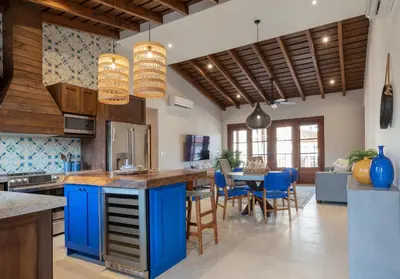 a kitchen with blue cabinets and a table with chairs at Calle Cartagena 8C in Playa Danta