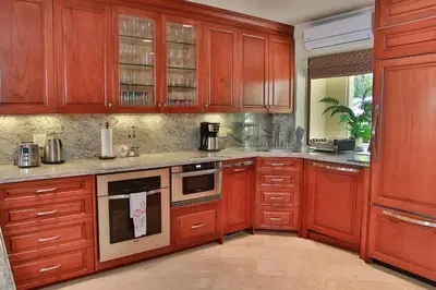 a kitchen with wooden cabinets and an oven at Palms 3- Luxury Beachfront Villa in Playa Flamingo