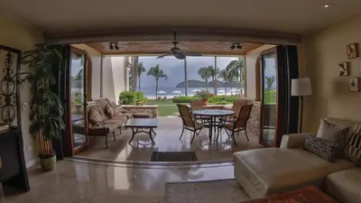 a living room with a couch and a table and chairs at Palms 3- Luxury Beachfront Villa in Playa Flamingo