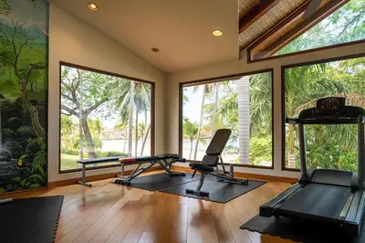 a gym with two exercise machines and large windows at Palms 3- Luxury Beachfront Villa in Playa Flamingo