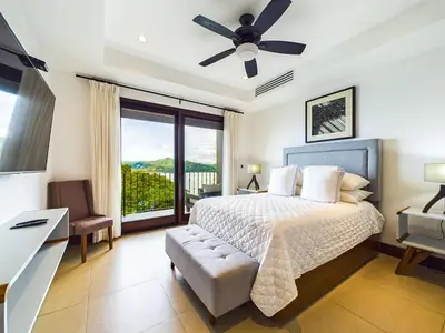 a bedroom with a bed and a desk and a window at 360 Splendor 309-Ocean View Residence-Breakfast Included! in Playa Flamingo