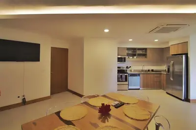 a dining room with a table and a kitchen at Peninsula 25 in Tamarindo
