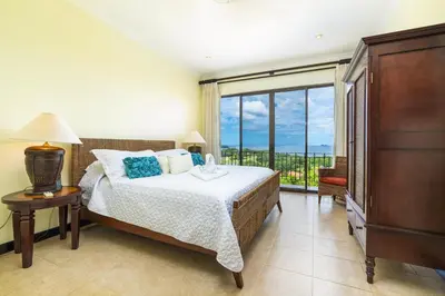 a bedroom with a bed and a large window at Malinche 423-B, Ocean View 2 Br Condo At Reserva Conchal in Brasilito