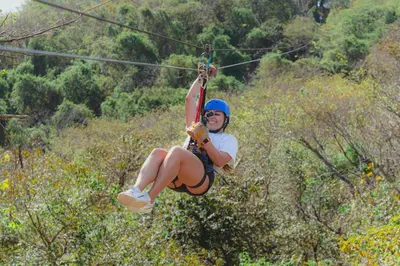 a woman is riding on a zip line at Malinche 423-B, Ocean View 2 Br Condo At Reserva Conchal in Brasilito