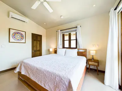 a bedroom with a large bed and a window at Miraflores 42 Ocean View Condo At Las Catalinas in Playa Danta