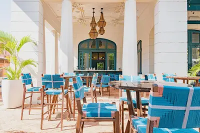 a restaurant with blue chairs and tables and a bar at Miraflores 42 Ocean View Condo At Las Catalinas in Playa Danta