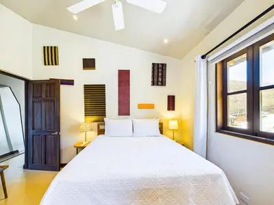 a bedroom with a white bed and a window at Miraflores 42 Ocean View Condo At Las Catalinas in Playa Danta