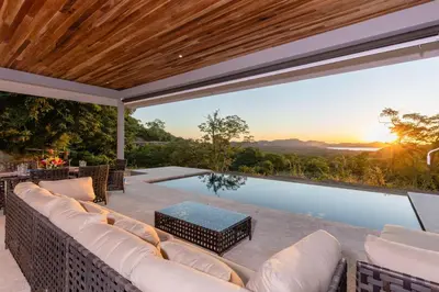 an outdoor patio with a couch and a swimming pool at Casa De Los Sueños, Brand New Ocean View Home On 125 Acres! in Brasilito