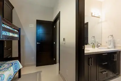 a bathroom with a sink and a black door at Casa De Los Sueños, Brand New Ocean View Home On 125 Acres! in Brasilito
