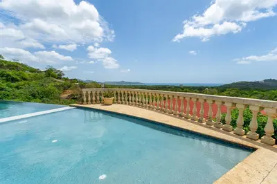 a swimming pool on a balcony with a fence at Casa De Los Sueños, Brand New Ocean View Home On 125 Acres! in Brasilito